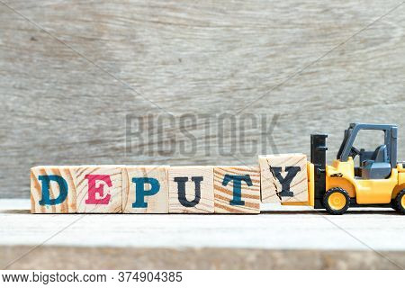 Toy Forklift Hold Letter Block Y To Complete Word Deputy On Wood Background