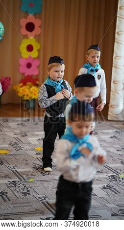 Portrait Of Cute Funny Boys In White Shirt And Blue Neckerchief And Forage-cap In Kindergarten