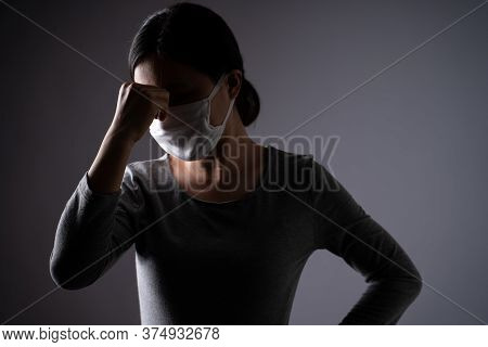 Asian Woman Wearing Protective Face Mask Was Sick With Headache Touching Her Head And Standing Isola