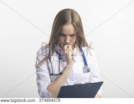 Female Doctor With Stethoscope Looking Careworn While Looking At Test Results With Pen Near Doctor M