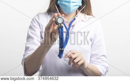 Close Up Portrait Of Unrecognizable Caucasian Doctor Woman In Face Mask With Stethoscope Using In Di