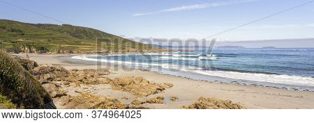 View Of The Beach With Large Rocks In The Sand And Mountains. Cayon Beach, Galicia.