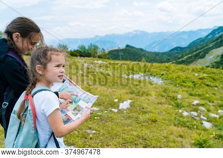 Children Hiking On Beautiful Summer Day In Alps Mountains Austria Resting On Rock. Kids Look At Map 
