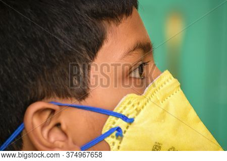 Isolated Young Indian Boy With Prominent Eyes Wearing N95 Face Mask For Protection Against Covid 19.