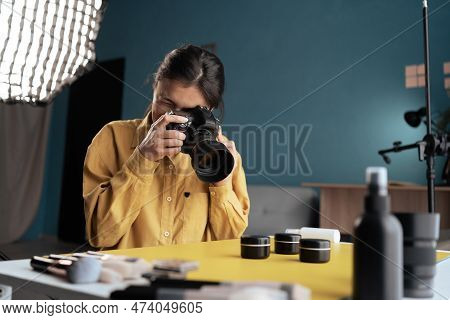 Professional Photographer Taking Photo Of Cosmetic Products On Desktop, Using Camera And Natural Lig