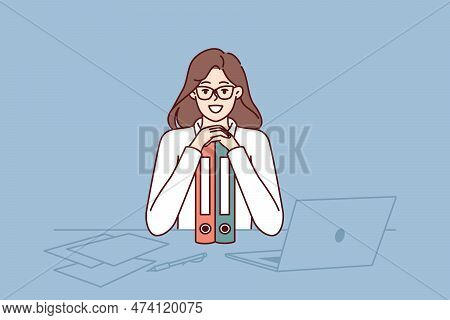 Business Woman Sits At Table Leaning On Folders And Smiling Looking At Camera Rejoicing At Success I