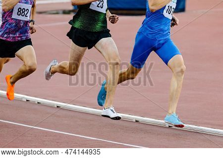 Three Runners Athletes On Middle Distance Running Together In Track Stadium, Summer Athletics Champi