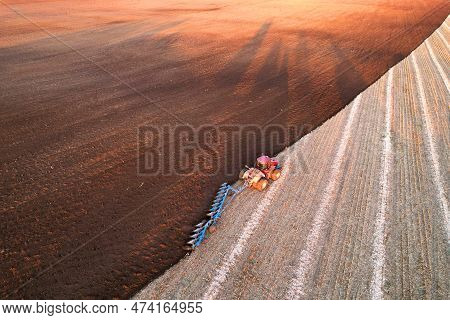 Tractor Plowing field, top view. Cultivated and soil tillage. Tractor on land cultivating. Agricultu