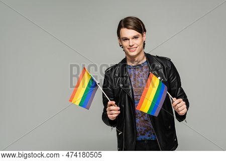 Happy Pangender Person In Black Leather Jacket Holding Small Lgbt Flags And Smiling At Camera Isolat