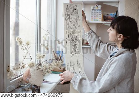 Female Artist Look At Her Work Drawing With Pen And Black Ink. Graphic Painting. Creating Modern Art