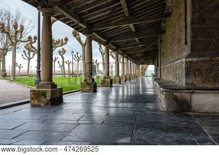 Passageway With Arched Doors And Wooden Roof With Old Stone Columns In The Church Of Luanco, Asturia