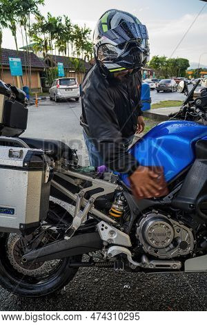 Perak, Malaysia - Aug 12, 2022 Wiping The Rain Drops On The Yamaha Motorcycle At The Rext And Relax 