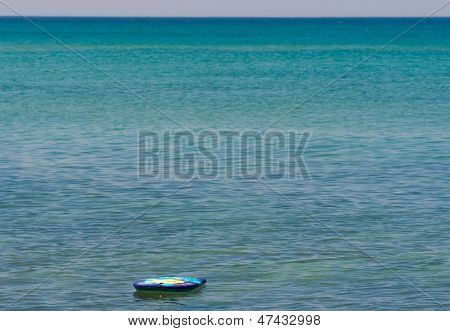 A Lonely Surfboard In The Sea