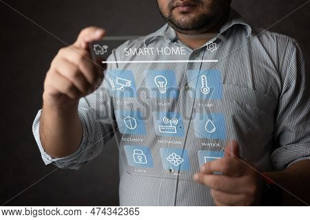Man Controlling Home Through The Dashboard Digital Tag. Concept Of Smart Home And Control All Device