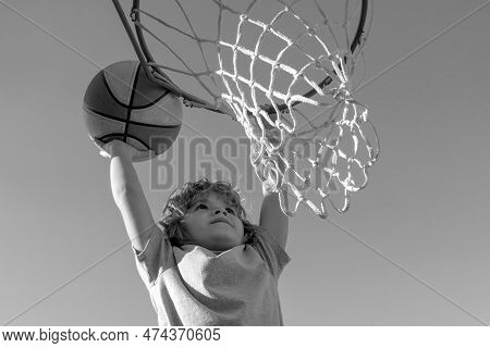 Basketball Slam Dunks Of Sporty Kids Basketball Player. Close Up Image Of Basketball Excited Kid Pla