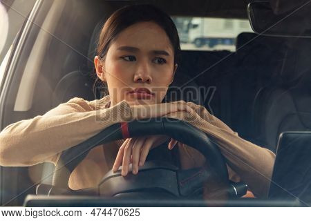 Asian Woman With Her Hands On The Steering Wheel Feeling Exhausted, Stressed With Work, Thinking Abo