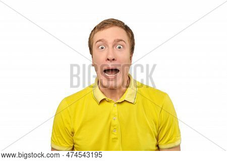 Surprised Young Man With Funny Facial Expression In Yellow T-shirt, White Isolated Background. Shock