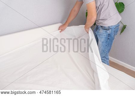 A Man Makes His Cozy Bed With Fresh Bright White Bed Linen. Making The Bed With Fresh Bed Linen By W