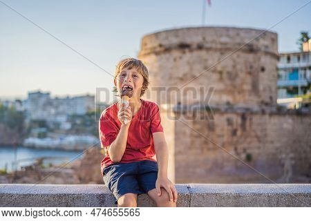 Boy Tourist Eating Turkish Ice Cream On Background Of Hidirlik Tower In Antalya Against The Backdrop