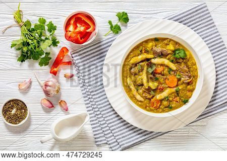 Gungo Peas, Pigeon Peas Soup With Dumplings , Vegetables And Beef In White Bowl On White Wood Table 
