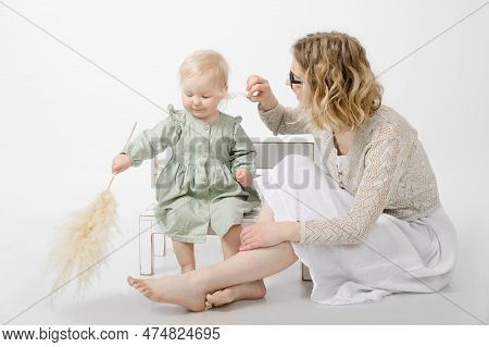 Portrait Of Cute Little Blond Girl Holding Branch Of Dried Pampas Grass. Young Woman Tickling Face W