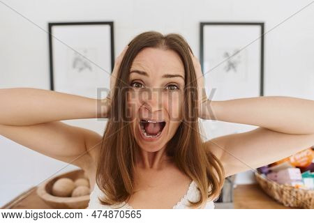 Portrait Of Young Woman Standing In Light Living Room On Daytime And Expressing Emotions. Shouting. 
