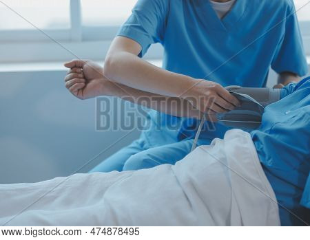 Injured Patient Showing Doctor Broken Wrist And Arm With Bandage In Hospital Office Or Emergency Roo