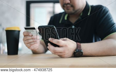 Men Use Credit Cards For Shopping Payments Online On Mobile Phone Applications Or Websites At Cafe. 
