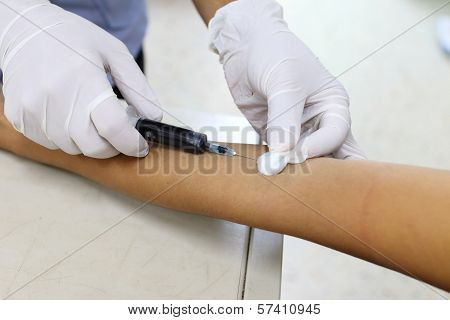 Nurse Taking Blood Sample From Patient At The Doctors Office