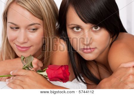 Close-up Of Two Young  Woman With Red Rose