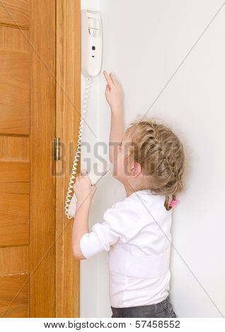 Little Girl Talking On The Intercom At Home.