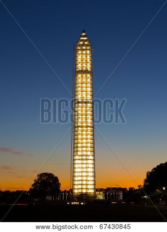 Washington Monument at sunset in illuminated scaffolding.