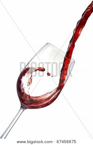 Pouring red wine into a crystal glass creates waves, splash.