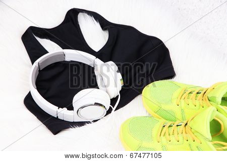 Sport clothes, shoes and headphones on white carpet background. 