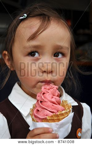 Cute mixed girl eating a strawberry icecream