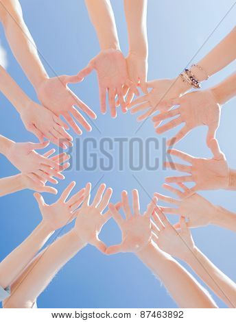 togetherness, team, union, people and gesture concept - close up of many hands over blue sky background