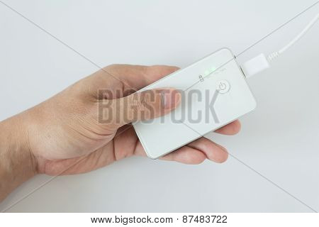 Male Hand Plugging In The Plug Of His Power Bank In A Socket