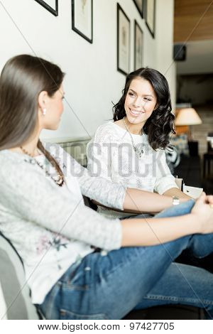 Two Beautiful Ladies Talking In A Bar