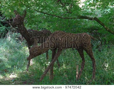 Wicker Deers Within Forest Landscape