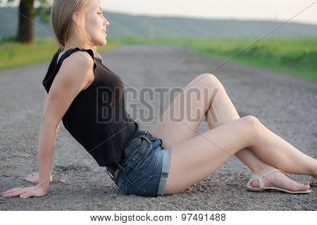 Beautiful Girl Sitting On The Road