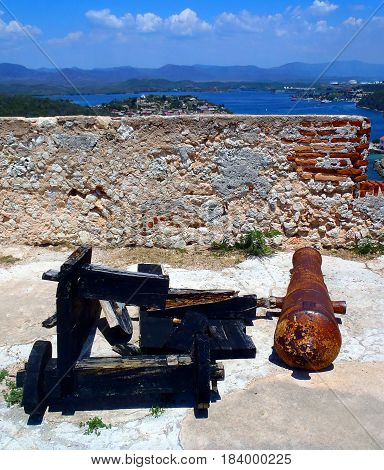 An old cannon at a stone fort on a hill
