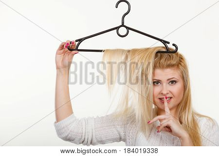 Wardrobe accessories haircare hair styling and selling concept. Blonde woman holding hair on clothes hanger