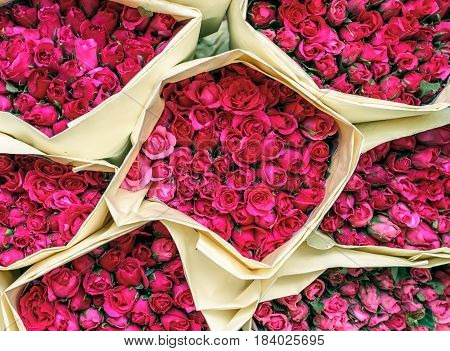 Beautiful pink small roses in paper bouquets, top view, at Bangkok flower market Thailand.