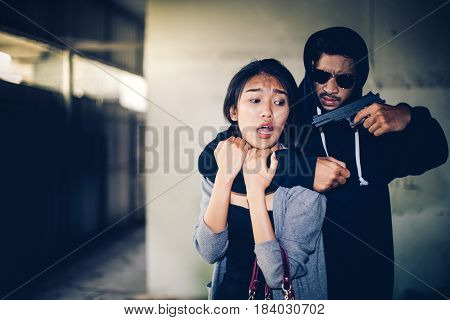 Man In Hoodie Robbing And Threatening With Gun To Frightened Young Woman. Criminal And Robbery For W