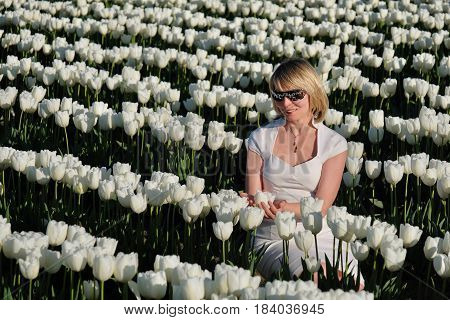Blond woman in white flowers. Tulip Festival. Abbotsford. British Columbia. Canada.