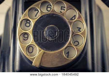 Old vintage telephone with brass rotary dial