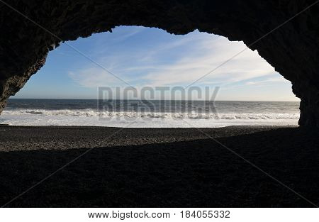 Waves rolling ashore from a cove on Reynisfjara beach in Iceland.