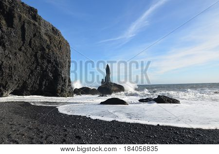 Reynisfjara beach with sea stacks and ocean waves crashing.