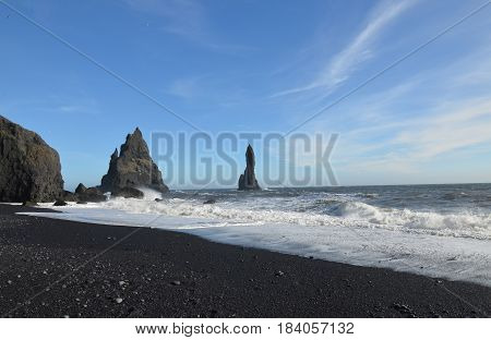 Beautiful volcanic black rock sea stacks off the coast of Reynisfjara beach.