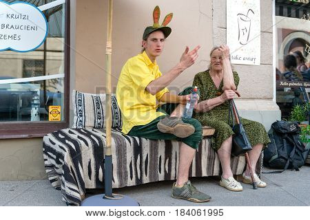 RIGA LATVIA - MAY 24 2014: Miera street Pentecost. Unknown people sat on the roadside and talked.